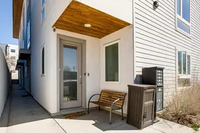 a porch with a bench next to a house at Walk to Mile High Stadium Modern Denver Townhome in Denver