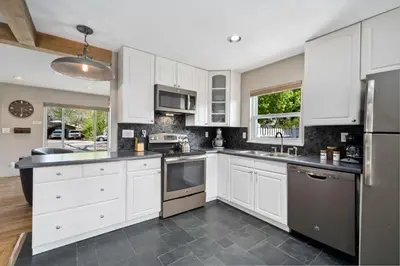a kitchen with white cabinets and stainless steel appliances at Magnolia Hideaway Pet Friendly with Fireplace in Fort Collins
