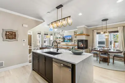 a kitchen with a sink and a living room at Decked Out Sunset Views, Fire Pit & Fenced Yard in Fort Collins