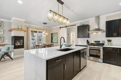 a kitchen with black cabinets and a white counter top at Decked Out Sunset Views, Fire Pit & Fenced Yard in Fort Collins
