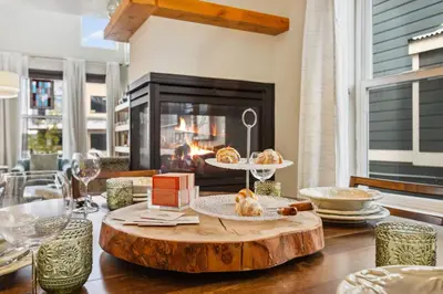 a living room with a table with a fireplace at Decked Out Sunset Views, Fire Pit & Fenced Yard in Fort Collins