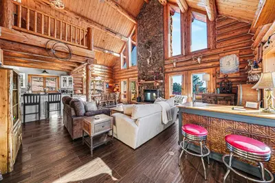 a living room with a bar in a log cabin at The Broadmeadow Cabin - VR-25-0005 cabin in Lyons