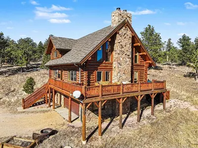 a log cabin with a wrap around deck at The Broadmeadow Cabin - VR-25-0005 cabin in Lyons