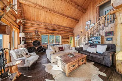 a living room with couches and a table in a cabin at The Broadmeadow Cabin - VR-25-0005 cabin in Lyons