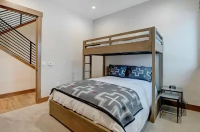 a bedroom with a bunk bed and a staircase at 4BR Winter Park Oasis - Sleeps 9 - Ski-In and Hot Tub in Winter Park