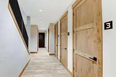 a hallway with a row of wooden doors in a building at 4BR Winter Park Oasis - Sleeps 9 - Ski-In and Hot Tub in Winter Park