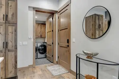a laundry room with wooden cabinets and a mirror at 4BR Winter Park Oasis - Sleeps 9 - Ski-In and Hot Tub in Winter Park