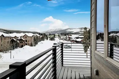 a balcony with a view of a snow covered town at 4BR Winter Park Oasis - Sleeps 9 - Ski-In and Hot Tub in Winter Park