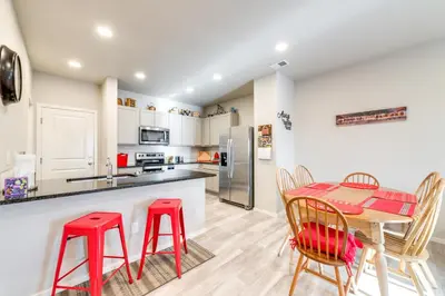 a kitchen with a table and two red stools at 11 Mi to Fort Collins Wellington Retreat with Patio in Wellington