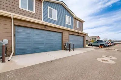 a house with two garage doors in a driveway at 11 Mi to Fort Collins Wellington Retreat with Patio in Wellington