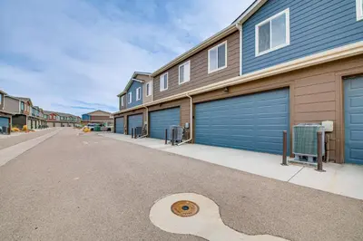 a row of garages with blue garage doors on a street at 11 Mi to Fort Collins Wellington Retreat with Patio in Wellington