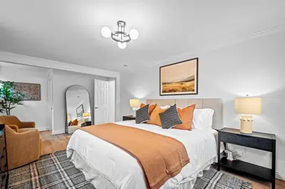 a bedroom with a large bed and a chair at Quiet Denver Hampden Neighborhood - Tech Center in Denver