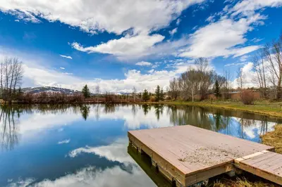 a dock on a lake with a cloudy sky at Modern Granby Retreat Fish, Hike and Relax! in Granby