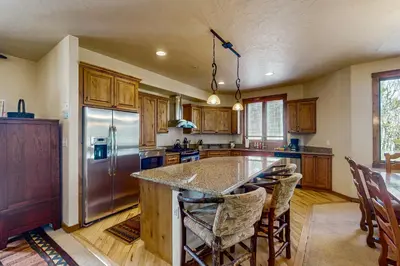 a kitchen with a large island with bar chairs at Trailside Tranquility in Winter Park