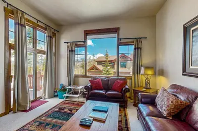 a living room with a couch and a table at Trailside Tranquility in Winter Park