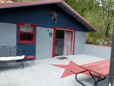a blue building with a table and stars on it at American-Themed Vacation Cabin with a Spacious Deck in Poudre Canyon near Fort Collins, Colorado in Fort Collins