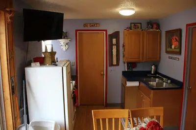 a kitchen with a white refrigerator and a sink at American-Themed Vacation Cabin with a Spacious Deck in Poudre Canyon near Fort Collins, Colorado in Fort Collins