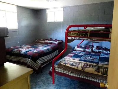 a room with two bunk beds in a room at American-Themed Vacation Cabin with a Spacious Deck in Poudre Canyon near Fort Collins, Colorado in Fort Collins