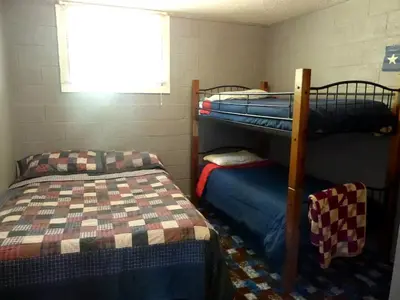 a room with two bunk beds and a window at American-Themed Vacation Cabin with a Spacious Deck in Poudre Canyon near Fort Collins, Colorado in Fort Collins
