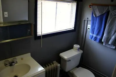 a bathroom with a toilet and a sink and a window at American-Themed Vacation Cabin with a Spacious Deck in Poudre Canyon near Fort Collins, Colorado in Fort Collins