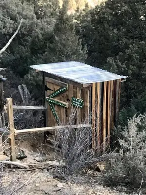 a wooden outhouse with a solar roof in a field at Special Glamping Accommodation Ideal for Nature Lovers in Golden, Colorado in Golden