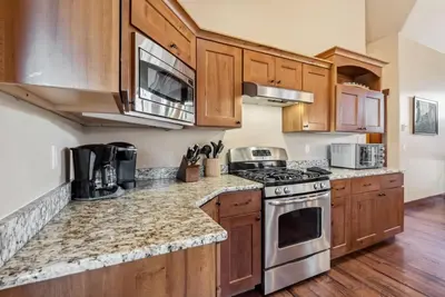 a kitchen with wooden cabinets and stainless steel appliances at Spacious Ski Townhome with Game Room Fun in Breckenridge