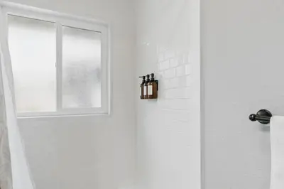 a white bathroom with a shower with a window at Projector Nights And Park Delights Designer Reno in Arvada