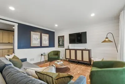 a living room with a couch and a tv at Projector Nights And Park Delights Designer Reno in Arvada