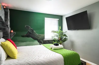 a bedroom with a bed with a green wall at Movie Theater + Hot Tub | Game Yard | Sleeps 10! in Arvada