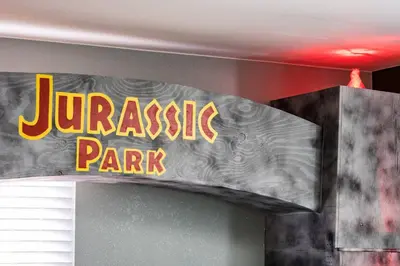 a sign for a jurassic park sign on a wall at Movie Theater + Hot Tub | Game Yard | Sleeps 10! in Arvada