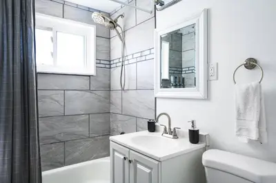a white bathroom with a sink and a shower at Movie Theater + Hot Tub | Game Yard | Sleeps 10! in Arvada