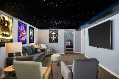 a living room with a couch and a flat screen tv at Movie Theater + Hot Tub | Game Yard | Sleeps 10! in Arvada
