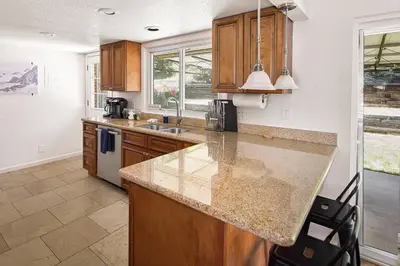 a kitchen with wooden cabinets and a counter top at Family Retreat! By Denver + Hot Tub, Sleeps 10! in Wheat Ridge