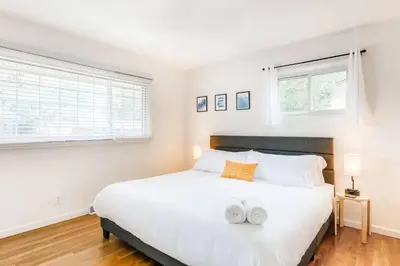 a bedroom with a large white bed with two towels on it at Family Retreat! By Denver + Hot Tub, Sleeps 10! in Wheat Ridge