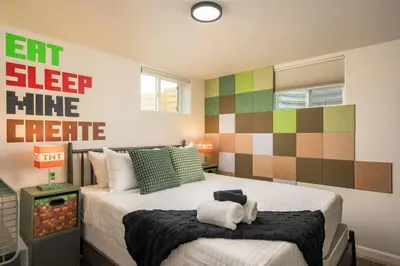 a bedroom with a bed with two towels on it at Mini Golf • Fire Pit • Hot Tub | Game House for 14 in Arvada