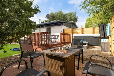 a patio with chairs and a fire pit in a yard at Mini Golf • Fire Pit • Hot Tub | Game House for 14 in Arvada