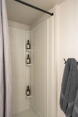 a bathroom with a tub and a shower with a towel at Mini Golf • Fire Pit • Hot Tub | Game House for 14 in Arvada