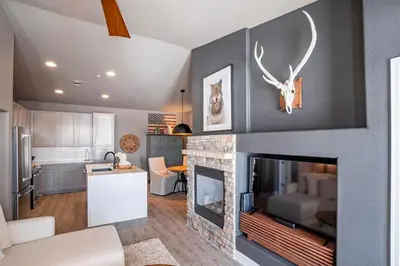 a living room with a fireplace and a kitchen at Aspen Meadows C-303, 0017 in Granby