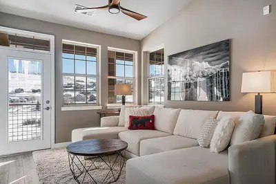 a living room with a white couch and windows at Aspen Meadows C-303, 0017 in Granby