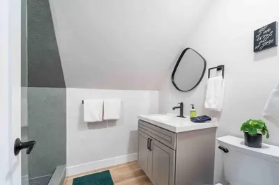 a white bathroom with a sink and a mirror at Morrison Getaway - 2BR House BBQ Free Parking in Morrison