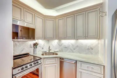 a kitchen with white cabinets and a sink at Historic French Consulate! Cap Hill Area, Walkable in Denver