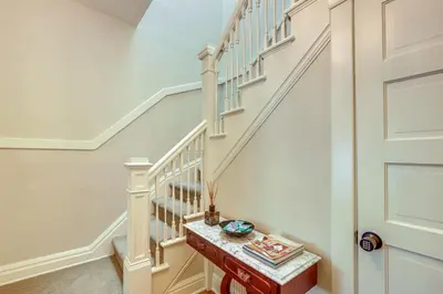 a white staircase with white railings and a wooden table at Historic French Consulate! Cap Hill Area, Walkable in Denver