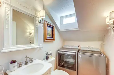 a bathroom with a sink and a washing machine at Historic French Consulate! Cap Hill Area, Walkable in Denver