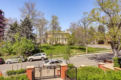 a parking lot with cars parked in front of a house at Historic French Consulate! Cap Hill Area, Walkable in Denver