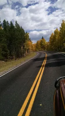 an empty road with two yellow lines in the middle at Bluejay bunkhouse in Grand Lake