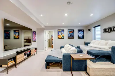 a living room with a blue couch and a tv at 1 Mi to Dtwn Denver Sleek Duplex with Rooftop Deck! in Denver