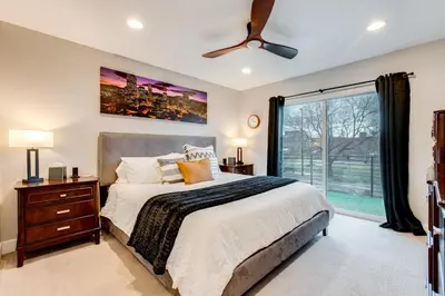 a bedroom with a bed and a large window at 1 Mi to Dtwn Denver Sleek Duplex with Rooftop Deck! in Denver