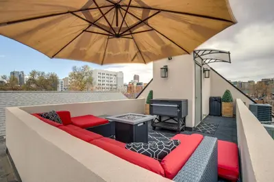 a patio with a couch and an umbrella and a piano at 1 Mi to Dtwn Denver Sleek Duplex with Rooftop Deck! in Denver
