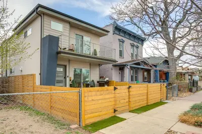 a house with a fence in front of it at 1 Mi to Dtwn Denver Sleek Duplex with Rooftop Deck! in Denver