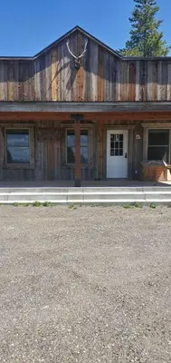 a large wooden building with a white door at Cowboy cabin in Grand Lake